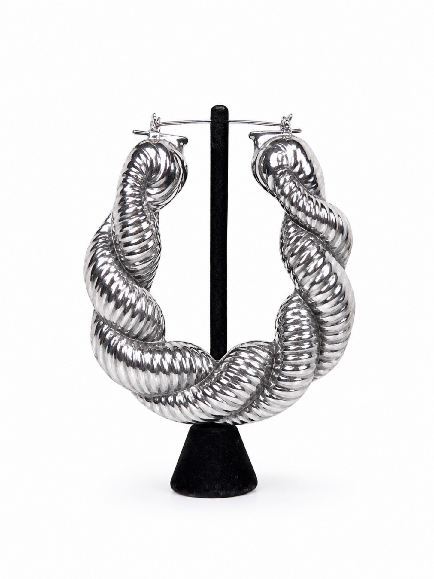 Silver twisted statement hoop earrings with sculpted ribbed texture and high-shine metallic finish.