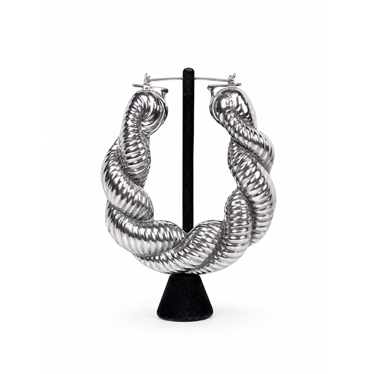 Silver twisted statement hoop earrings with sculpted ribbed texture and high-shine metallic finish.