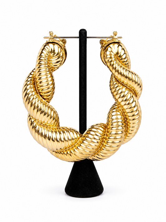 Gold twisted hoop earrings with sculpted ribbed texture and high-shine metallic finish.

